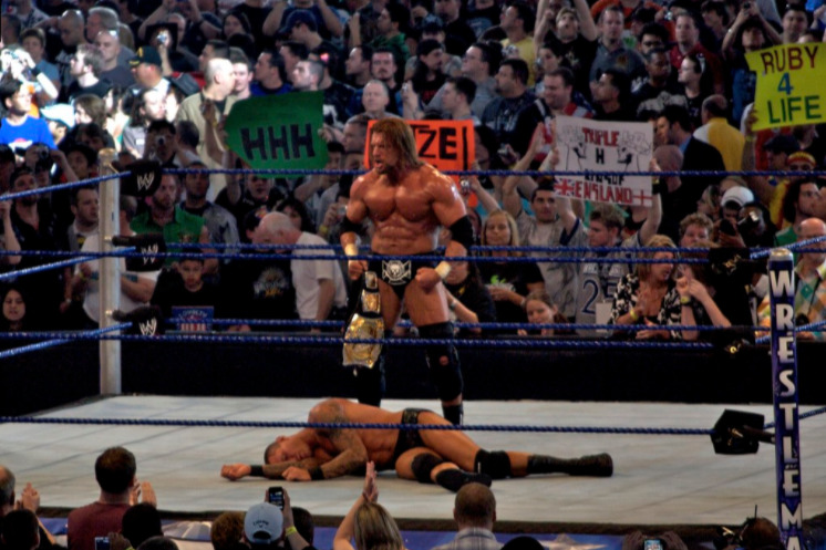 Triple H standing over Randy Orton - Wrestling Examiner